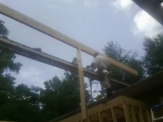 Carpenter setting a ridge beam over a new addition frame — Ice Dam Removal by Roofing Brothers in Newhall