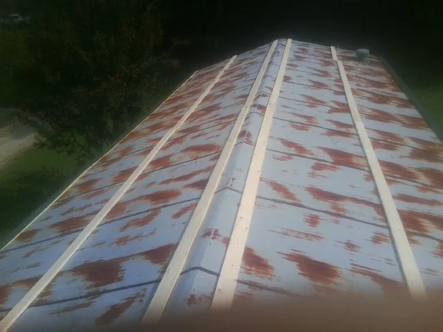 Rusted metal roof panels with new wood purlins before replacement — Storm Damage Roof Repair in Newhall by Roofing Brothers