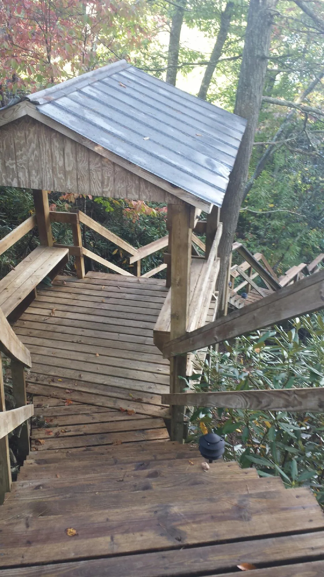 Metal roofed shelter over wooden steps on a wooded walkway — Skylight Repair & Installation work by our crew in Newhall